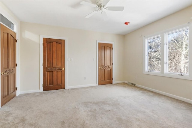 unfurnished bedroom featuring light carpet, visible vents, and baseboards