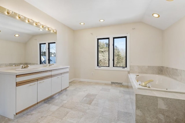 bathroom with double vanity, visible vents, a bath, vaulted ceiling, and a sink