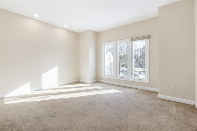 carpeted empty room featuring recessed lighting and baseboards