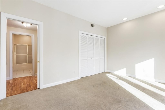 unfurnished bedroom featuring a closet, carpet, visible vents, and recessed lighting