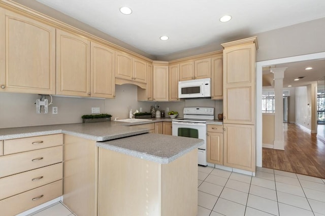 kitchen featuring white appliances, light countertops, light brown cabinets, a sink, and recessed lighting