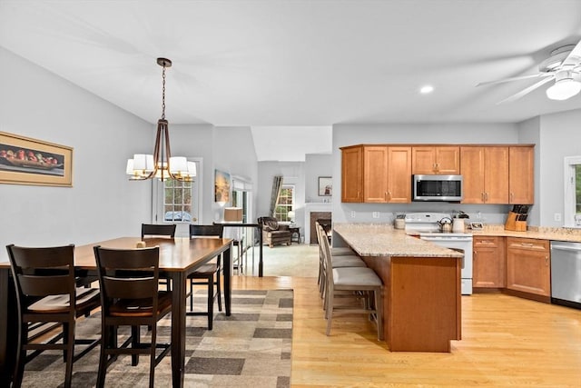7 Hemlock, Kingston, MA 02364 - kitchen featuring decorative light fixtures, a kitchen bar, a peninsula, light wood finished floors, and stainless steel appliances