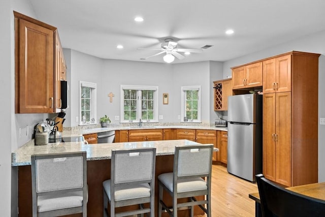 7 Hemlock, Kingston, MA 02364 - kitchen with a sink, light wood-style floors, a peninsula, light stone countertops, and stainless steel appliances