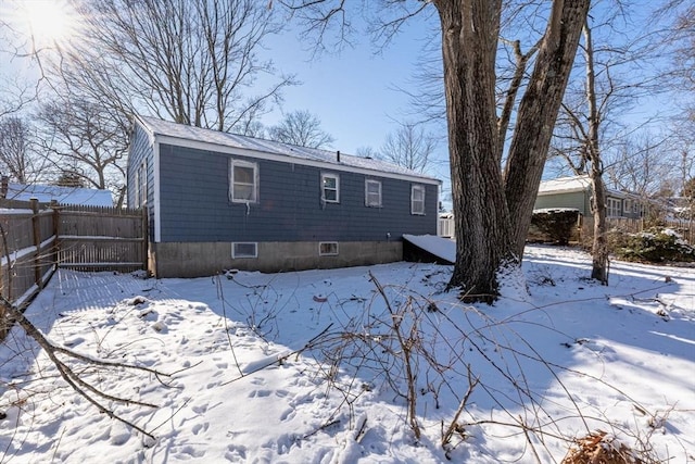 view of snow covered back of property