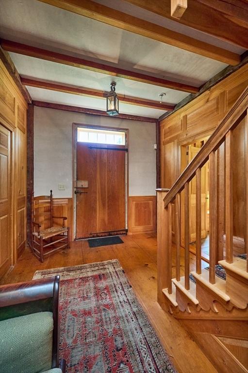 foyer with beamed ceiling and wood-type flooring