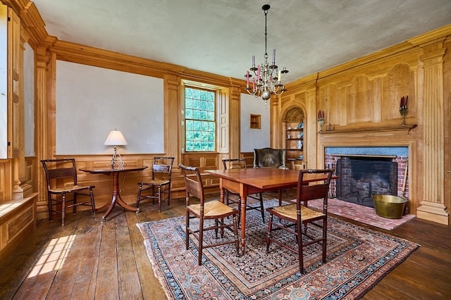 dining area with a fireplace, a chandelier, and dark wood-type flooring