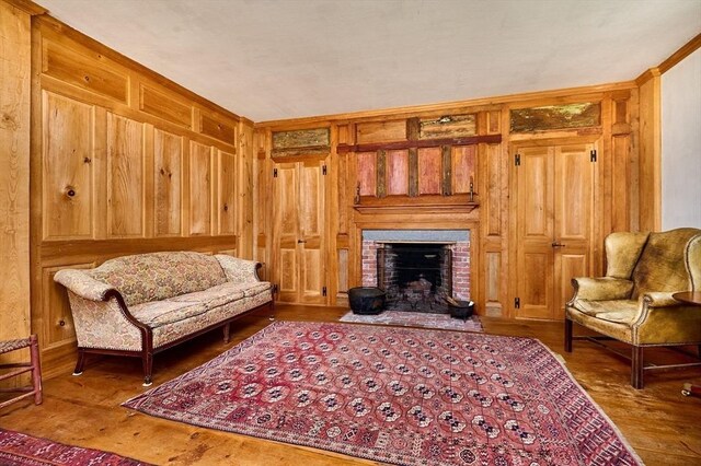 sitting room with wood walls and a brick fireplace