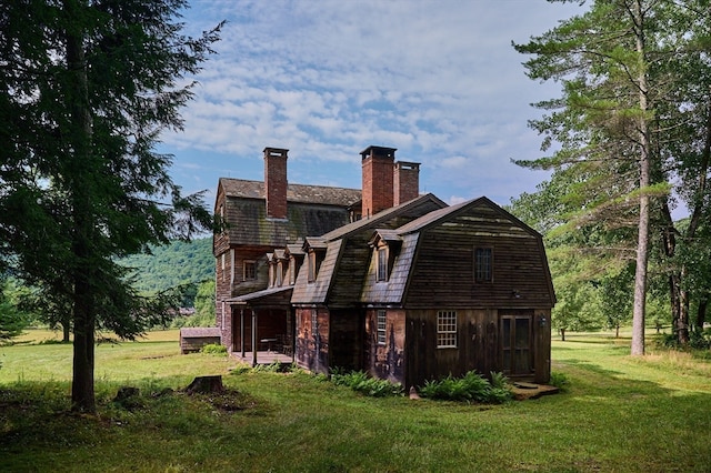 rear view of property featuring a lawn