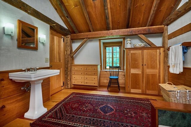 bathroom featuring wooden ceiling, wood-type flooring, lofted ceiling with beams, and wooden walls