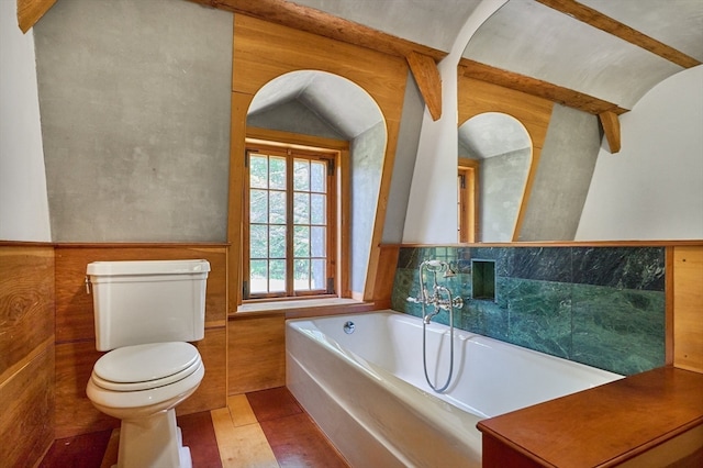 bathroom featuring tile patterned floors, a tub to relax in, and toilet