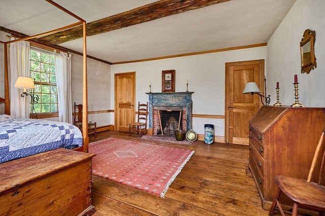 bedroom with dark hardwood / wood-style floors, a brick fireplace, and ornamental molding