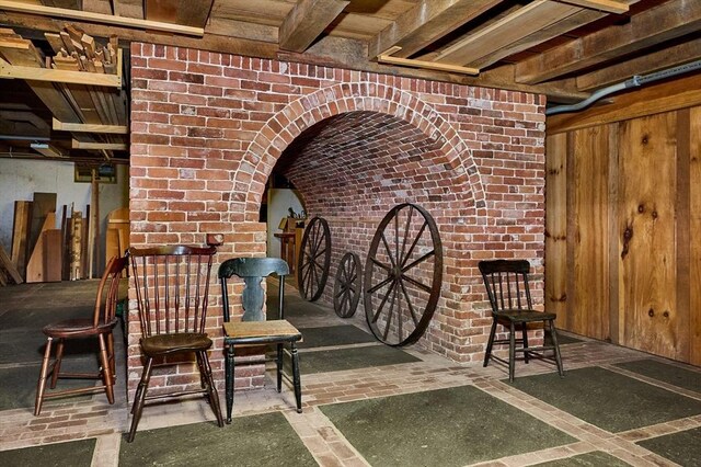 interior space featuring wooden walls and brick wall