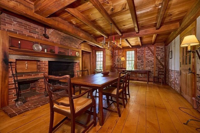 dining space featuring brick wall, wooden ceiling, and light hardwood / wood-style floors