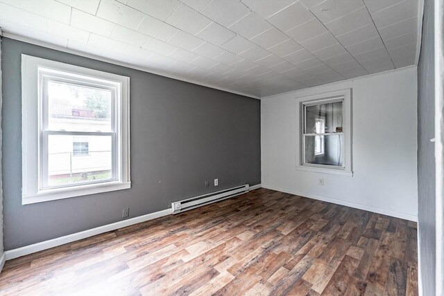 spare room with a baseboard heating unit and hardwood / wood-style flooring