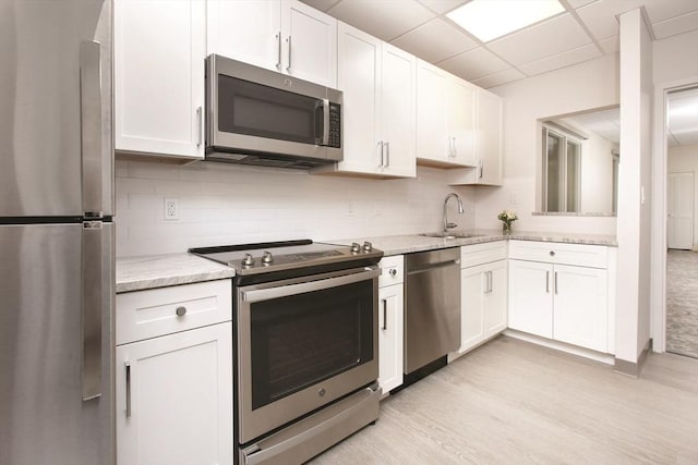 210 Nahanton St Unit 504, Newton, MA 02459 - kitchen featuring stainless steel appliances, a sink, white cabinets, tasteful backsplash, and a drop ceiling
