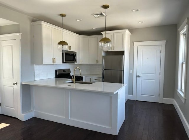 kitchen featuring white cabinetry, kitchen peninsula, stainless steel appliances, and pendant lighting