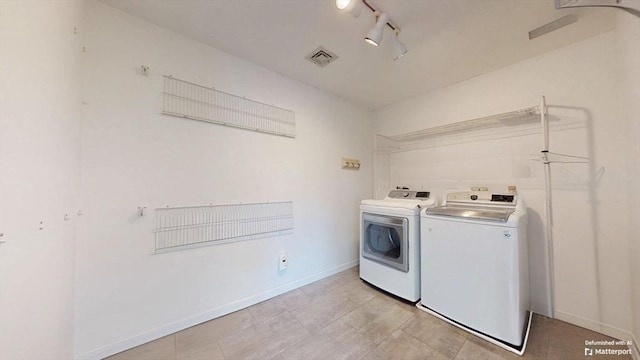 laundry room featuring laundry area, separate washer and dryer, rail lighting, baseboards, and visible vents