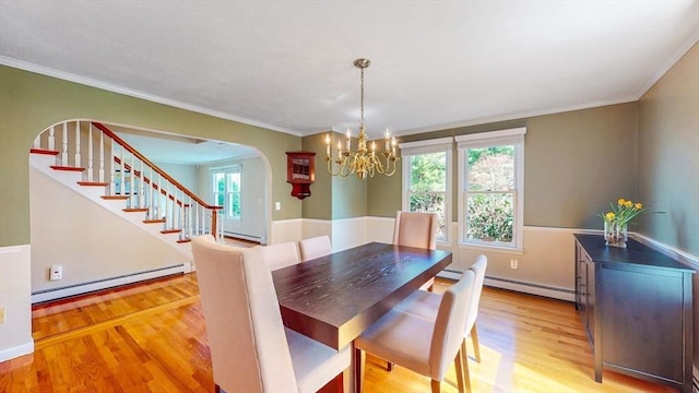 dining space with arched walkways, baseboard heating, a baseboard radiator, a notable chandelier, and light wood-style floors