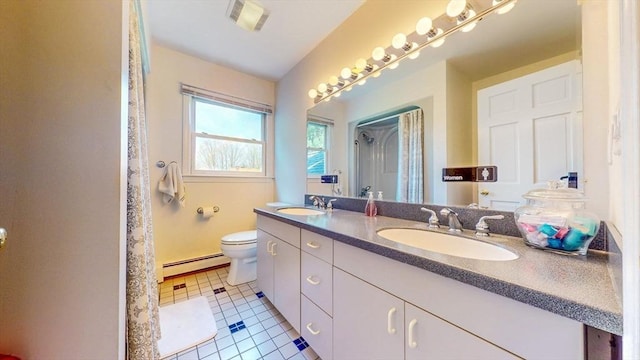 bathroom with a sink, tile patterned floors, baseboard heating, and toilet