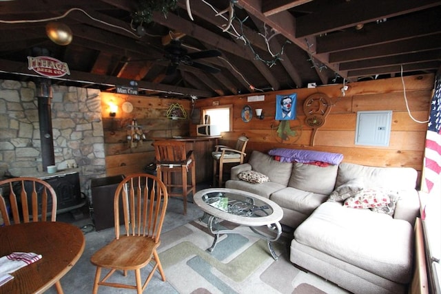 75 Wachusett St, Franklin, MA 02038 - living room featuring electric panel, wood walls, ceiling fan, a wood stove, and vaulted ceiling