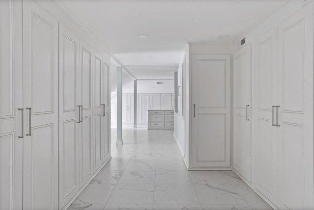 hall with a decorative wall, visible vents, and marble finish floor