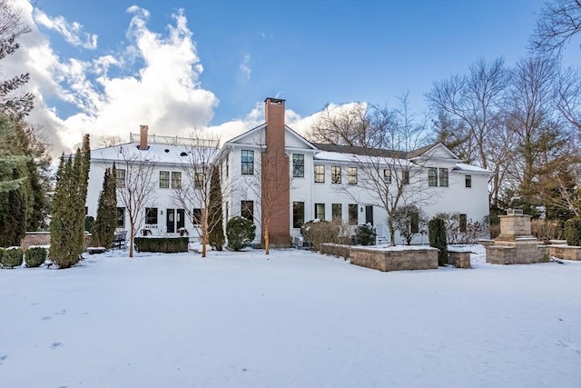 view of snow covered back of property