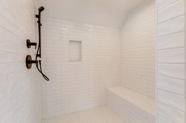 full bathroom featuring tiled shower and vaulted ceiling