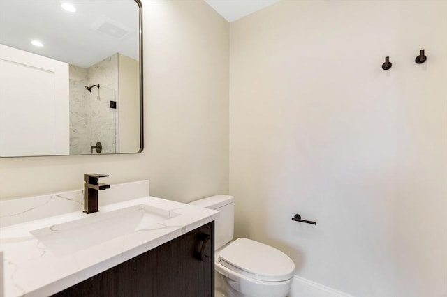 bathroom with recessed lighting, toilet, vanity, baseboards, and walk in shower