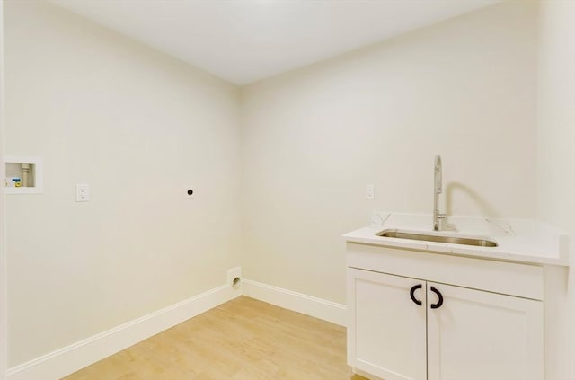 laundry room with hookup for a washing machine, light wood-style flooring, hookup for an electric dryer, a sink, and baseboards