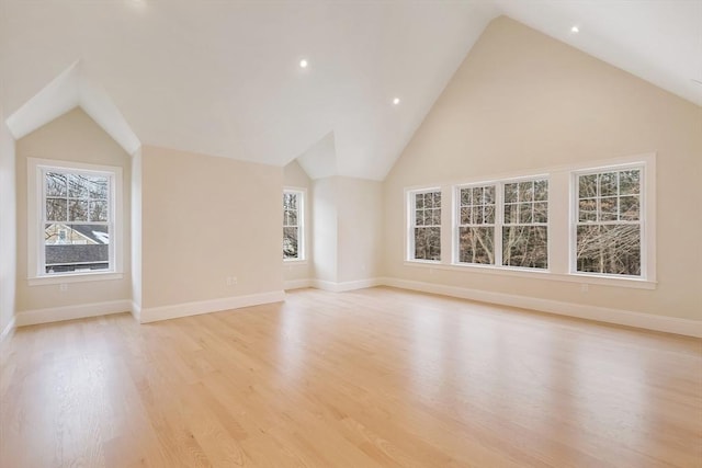 additional living space with high vaulted ceiling, light wood-style flooring, and baseboards