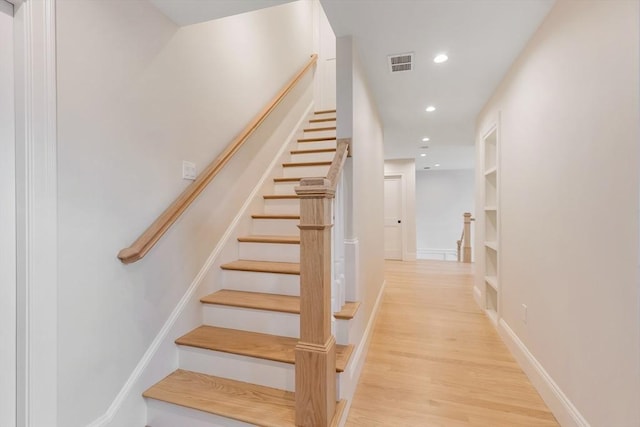 stairs featuring baseboards, visible vents, wood finished floors, and recessed lighting