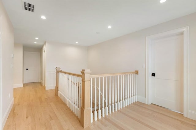 hall with recessed lighting, an upstairs landing, baseboards, visible vents, and light wood-style floors