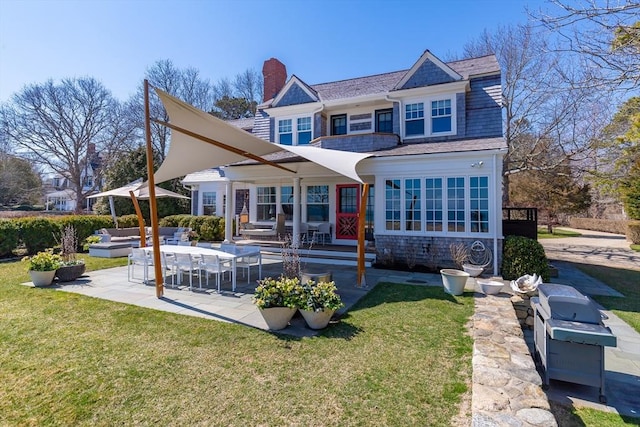 17 Mattarest Ln, Dartmouth, MA 02748 - back of property featuring a patio, a lawn, and a chimney