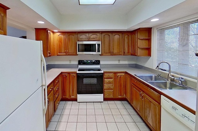 kitchen featuring white appliances, a sink, light tile patterned floors, brown cabinets, and recessed lighting