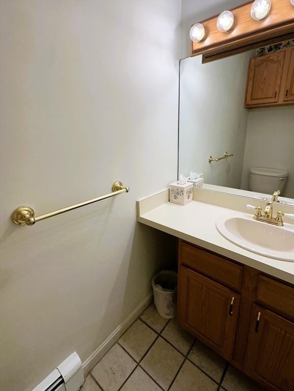 bathroom featuring toilet, tile patterned flooring, vanity, a baseboard heating unit, and baseboards