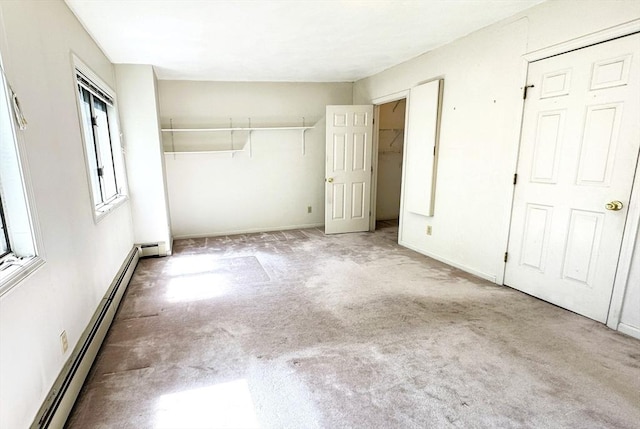 unfurnished bedroom featuring a baseboard radiator, carpet, a closet, and baseboards