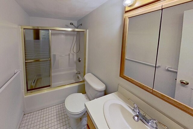 bathroom with vanity, toilet, combined bath / shower with glass door, and baseboards