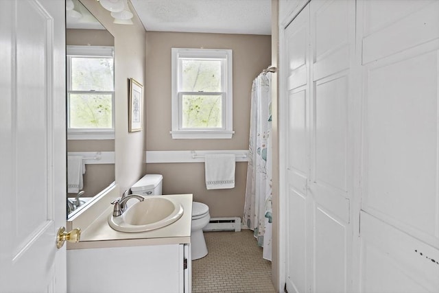 bathroom featuring a baseboard heating unit, toilet, vanity, and tile patterned flooring