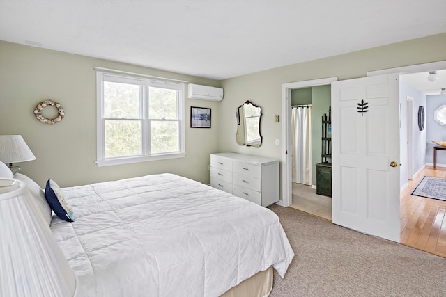 bedroom featuring a wall unit AC and light wood-type flooring