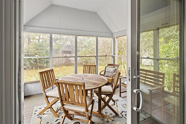 sunroom featuring vaulted ceiling and outdoor dining area
