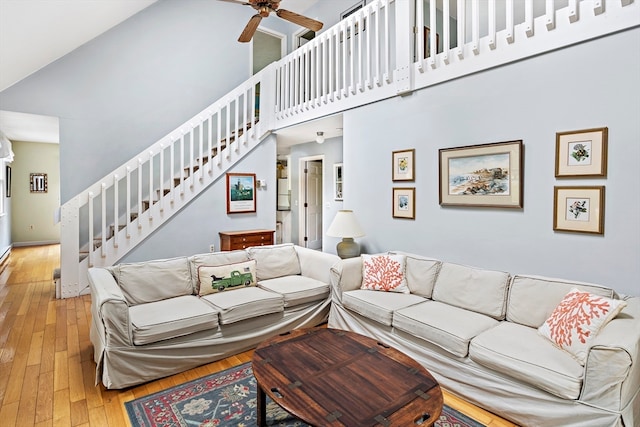 living room featuring hardwood / wood-style floors, a high ceiling, and ceiling fan