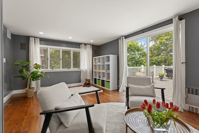 141 Jewett St Unit 2, Newton, MA 02458 - sitting room with radiator, wood finished floors, baseboards, and recessed lighting