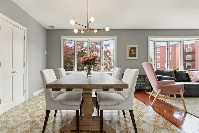 141 Jewett St Unit 2, Newton, MA 02458 - dining room featuring a chandelier, light wood finished floors, and baseboards