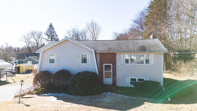 bi-level home featuring entry steps and brick siding