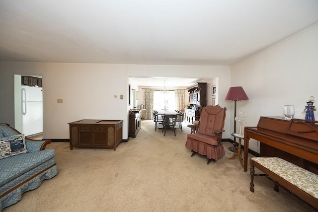 sitting room featuring baseboards and light colored carpet