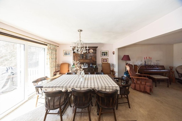 dining space with a notable chandelier and light colored carpet