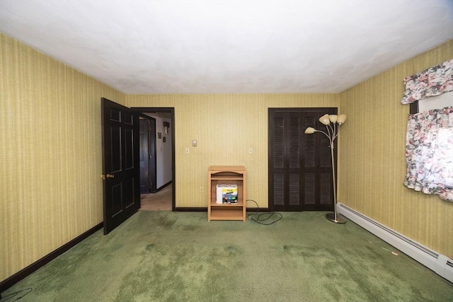 spare room featuring carpet, a baseboard radiator, baseboards, and wallpapered walls