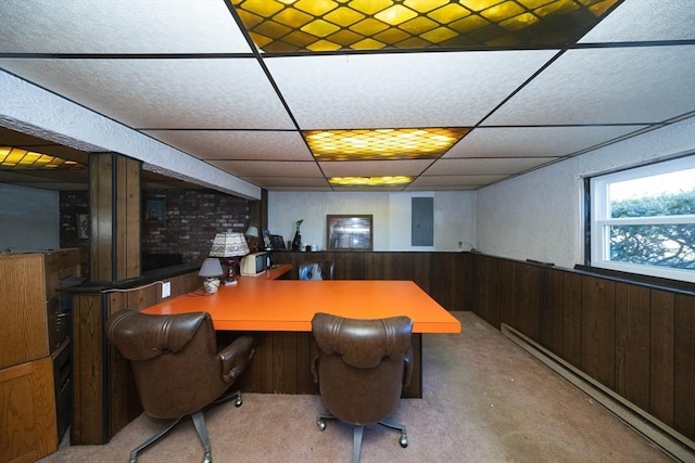 office area featuring a wainscoted wall, baseboard heating, a community bar, wood walls, and a drop ceiling