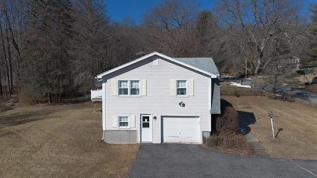 view of front of house featuring a garage, a front yard, and driveway