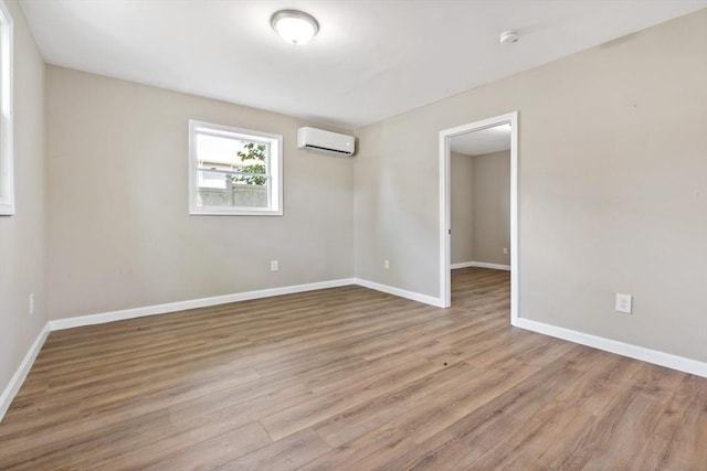 unfurnished room featuring light hardwood / wood-style flooring and a wall mounted AC